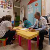 Ci sono due bambini di 8 anni, Samuele e Miriana e la 12enne Rebecca, intenti a giocare con le carte di "Uno" assieme due volontari...